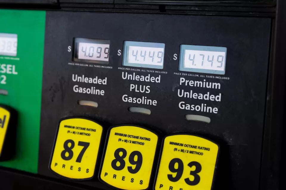 Close-up of gas pump with yellow buttons and price screens.